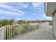 Grey deck with white railing overlooking water and palm trees, perfect for enjoying beautiful views and outdoor relaxation at 17404 1St E St, Redington Shores, FL 33708