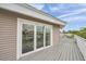 Corner view of deck with grey wood flooring and beige siding, showcasing a serene outdoor living space at 17404 1St E St, Redington Shores, FL 33708