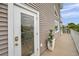 Exterior door with decorative glass insert, leading to a deck with railings and tropical plants at 17404 1St E St, Redington Shores, FL 33708