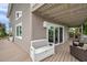 Covered outdoor deck with seating area and sliding glass doors leading into the home at 17404 1St E St, Redington Shores, FL 33708