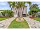 Charming two-story home with well-manicured landscaping and a spacious driveway, offering curb appeal at 17404 1St E St, Redington Shores, FL 33708
