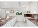 Modern kitchen with white cabinets, marble countertop, and stainless steel appliances offering a sleek design at 17404 1St E St, Redington Shores, FL 33708