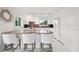 Kitchen with white cabinets, bar seating, track lighting, and marble island with barstool seating for casual dining at 17404 1St E St, Redington Shores, FL 33708