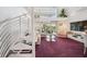 Open living area with spiral stairs, high ceilings, a TV, and sliding doors to the balcony at 17404 1St E St, Redington Shores, FL 33708