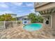 Outdoor swimming pool featuring brick pavers, white fencing, and lush landscaping for outdoor enjoyment at 17404 1St E St, Redington Shores, FL 33708