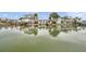 Waterfront property with boat dock and lift surrounded by lush landscaping and calm waters at 17404 1St E St, Redington Shores, FL 33708