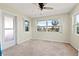 Bedroom with neutral walls, carpeted flooring, a door and multiple windows with views of palm trees at 1751 8Th Sw Ave, Largo, FL 33770