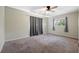 This bedroom features a ceiling fan, neutral walls, a window with curtains, and carpeted flooring at 1751 8Th Sw Ave, Largo, FL 33770