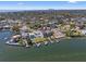 Aerial view of waterfront home with private docks, lush landscaping, and city skyline in the distance at 1843 Bayou Grande Ne Blvd, St Petersburg, FL 33703