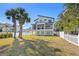 Spacious backyard featuring lush lawn, mature trees, a swing set, and an elegant white picket fence at 1843 Bayou Grande Ne Blvd, St Petersburg, FL 33703