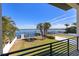 Waterfront backyard featuring a dock, boat lift, fenced yard, and tropical landscaping at 1843 Bayou Grande Ne Blvd, St Petersburg, FL 33703