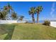 Spacious backyard showcases a lush lawn, mature palm trees, classic swing set and tranquil water views at 1843 Bayou Grande Ne Blvd, St Petersburg, FL 33703