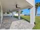 Expansive covered patio with ceiling fans and tranquil views of the landscaped backyard and serene waterfront at 1843 Bayou Grande Ne Blvd, St Petersburg, FL 33703