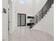Bright entryway boasts soaring ceilings, tiled floors, a modern staircase, and sleek front door at 1843 Bayou Grande Ne Blvd, St Petersburg, FL 33703