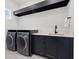 Modern laundry room featuring front load washer and dryer, counter space and ample cabinets at 1843 Bayou Grande Ne Blvd, St Petersburg, FL 33703