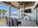 Outdoor kitchen with granite counters, grill, sink, covered ceilings, and waterfront views at 1843 Bayou Grande Ne Blvd, St Petersburg, FL 33703