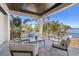 This tiled patio offers seating, a table, and views of the waterfront and tropical foliage at 1843 Bayou Grande Ne Blvd, St Petersburg, FL 33703