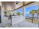 This tiled patio offers seating, ceiling fans, a bar, and views of the waterfront and tropical foliage at 1843 Bayou Grande Ne Blvd, St Petersburg, FL 33703
