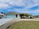 Charming single-story home with a light blue garage door and driveway at 18710 Van Nuys Cir, Port Charlotte, FL 33948