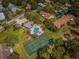Aerial view of community amenities, including a pool, tennis court, and lush landscaping at 2446 Bentley Dr, Palm Harbor, FL 34684
