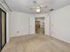 Bedroom with neutral carpet, ceiling fan, and an open doorway, creating an inviting space at 2446 Bentley Dr, Palm Harbor, FL 34684