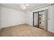 Carpeted bedroom with a ceiling fan, closet, and sliding glass door leading to an enclosed porch at 2446 Bentley Dr, Palm Harbor, FL 34684