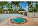 Community hot tub surrounded by a brick patio, fencing, and mature trees in a serene setting at 2446 Bentley Dr, Palm Harbor, FL 34684