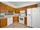 Well-maintained kitchen features classic wooden cabinets, white appliances, and a cozy breakfast nook at 2446 Bentley Dr, Palm Harbor, FL 34684