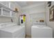 Functional laundry room equipped with a washing machine, dryer, and overhead shelving at 2446 Bentley Dr, Palm Harbor, FL 34684
