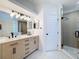 Modern bathroom with double sinks, white countertops and a walk-in shower at 2683 Sequoia Ter # 402, Palm Harbor, FL 34683