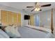 A well-lit bedroom featuring a ceiling fan and a wooden closet for ample storage at 3137 Valemoor Dr, Palm Harbor, FL 34685