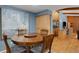 Cozy dining area adjacent to bar and eat-in kitchen featuring a round wood table and an eye-catching painting at 3137 Valemoor Dr, Palm Harbor, FL 34685