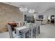 Dining area showcasing stone wall, modern chandelier lighting, and seamless flow to living room at 3137 Valemoor Dr, Palm Harbor, FL 34685