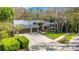 Exterior view of a home with a three-car garage, ample driveway, and manicured front lawn at 3137 Valemoor Dr, Palm Harbor, FL 34685