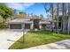 Charming single-story home with a three-car garage, manicured lawn, and beautiful landscaping at 3137 Valemoor Dr, Palm Harbor, FL 34685