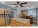 Bright kitchen with stainless steel appliances, large island, and breakfast nook with blue wall and abstract art at 3137 Valemoor Dr, Palm Harbor, FL 34685