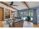 Cozy living room with stone fireplace, exposed beam, and access to screened in pool at 3137 Valemoor Dr, Palm Harbor, FL 34685