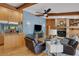 Inviting living room featuring a stone fireplace, bar access, hardwood floors, and comfortable leather furniture at 3137 Valemoor Dr, Palm Harbor, FL 34685