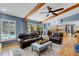 Spacious living room with beamed ceilings, hardwood floors, and sliding glass doors to the outdoor pool at 3137 Valemoor Dr, Palm Harbor, FL 34685