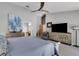 Inviting main bedroom with a gray armchair, stylish dresser and a large-screen television for ultimate relaxation at 3137 Valemoor Dr, Palm Harbor, FL 34685