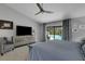 Relaxing main bedroom featuring a view of the pool, stylish accent chair and a modern media center at 3137 Valemoor Dr, Palm Harbor, FL 34685