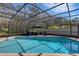 Stunning screened-in pool with clear blue water, surrounded by a brick patio and comfortable lounge seating for relaxation at 3137 Valemoor Dr, Palm Harbor, FL 34685