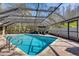 Sparkling pool featuring a screen enclosure, brick patio, and outdoor seating for comfortable poolside relaxation and enjoyment at 3137 Valemoor Dr, Palm Harbor, FL 34685