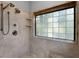 This shower features a glass block window, dual shower heads, and stone tile at 3137 Valemoor Dr, Palm Harbor, FL 34685