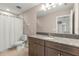 Bathroom featuring a granite countertop, stylish cabinets, and a shower with a curtain for a clean and modern look at 3148 Marine Grass Dr, Wimauma, FL 33598