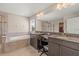A bathroom features double sinks, a separate tub, and a stand-up shower with a large mirror at 3148 Marine Grass Dr, Wimauma, FL 33598