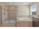 Elegant bathroom with soaking tub, glass shower, and neutral tile at 3148 Marine Grass Dr, Wimauma, FL 33598