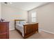Cozy bedroom with natural light, featuring a classic wooden bed frame and dresser at 3148 Marine Grass Dr, Wimauma, FL 33598