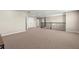 Large bonus room featuring neutral carpet, a staircase railing, and offering versatile space for various activities at 3148 Marine Grass Dr, Wimauma, FL 33598
