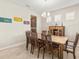 Dining room with tile flooring, a wooden table and chairs, and light fixtures overhead, ideal for Gathering gatherings at 3148 Marine Grass Dr, Wimauma, FL 33598
